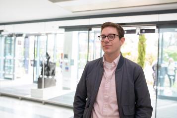 Man standing wearing a jacket in a hospital entrance