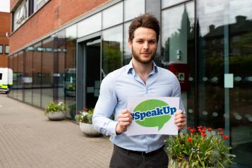 Man holding healthwatch speak up sign