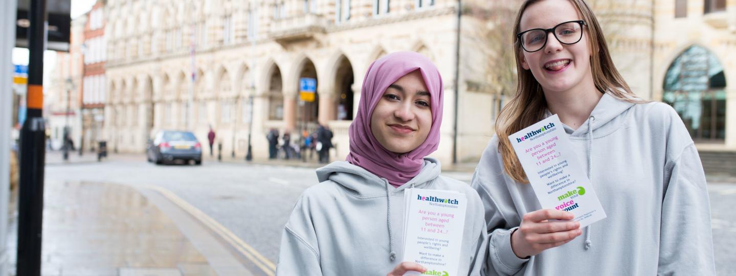 Two women holding healthwatch leaflets